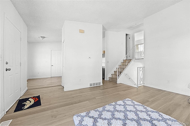 5112 Duluth Ct, Denver, CO 80239 - spare room with wood finished floors, a textured ceiling, and stairs