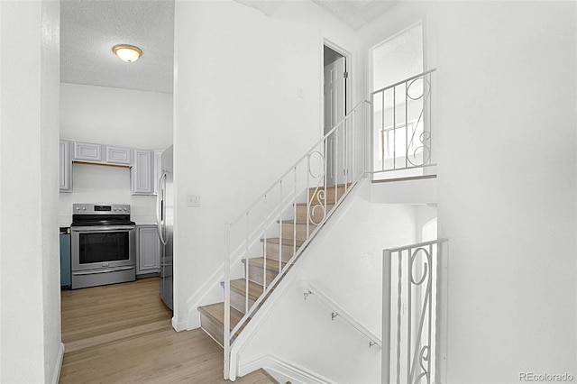 5112 Duluth Ct, Denver, CO 80239 - stairs featuring wood finished floors and a textured ceiling