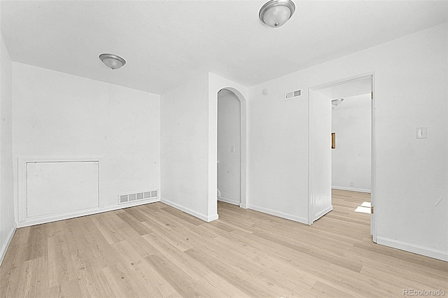 5112 Duluth Ct, Denver, CO 80239 - empty room featuring arched walkways and light wood finished floors