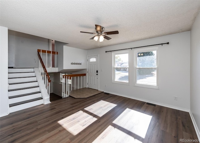 foyer entrance featuring a textured ceiling, dark hardwood / wood-style flooring, and ceiling fan