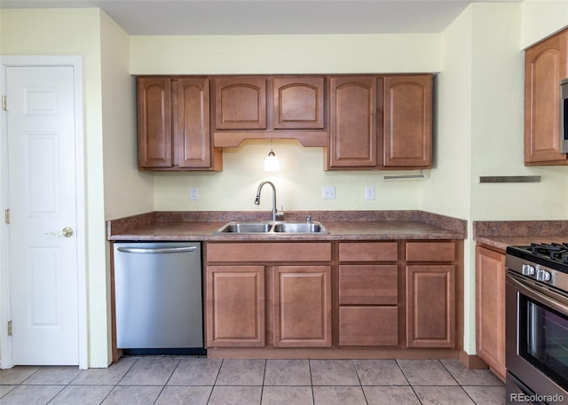 kitchen with sink, light tile patterned flooring, and stainless steel appliances