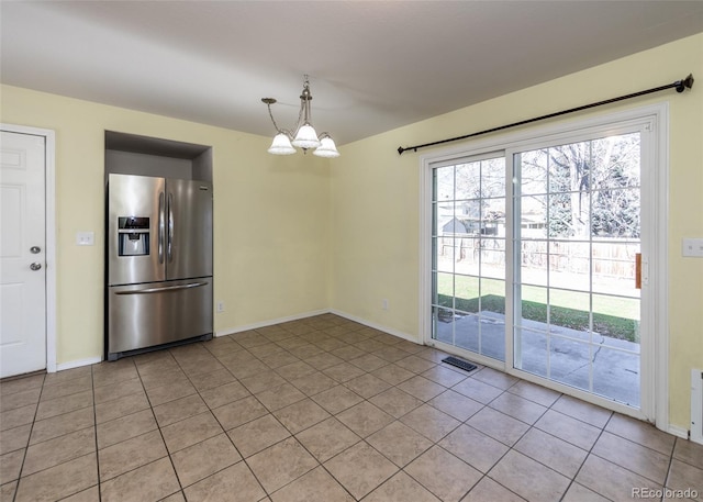 unfurnished dining area featuring light tile patterned floors and a chandelier