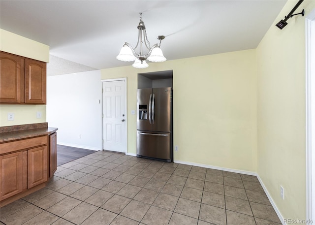 kitchen featuring tile patterned floors, decorative light fixtures, stainless steel refrigerator with ice dispenser, and a notable chandelier