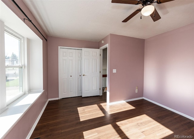 unfurnished bedroom with ceiling fan, dark hardwood / wood-style flooring, a textured ceiling, and a closet