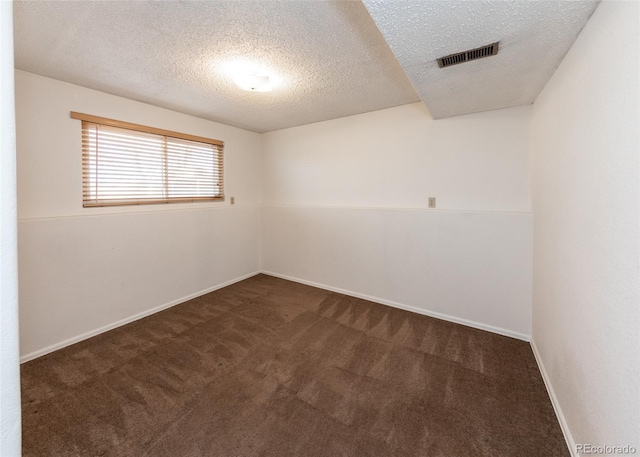 carpeted spare room with a textured ceiling