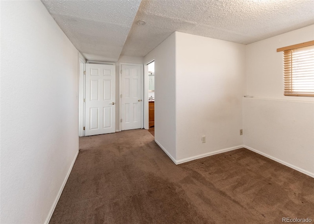 interior space featuring dark colored carpet and a textured ceiling