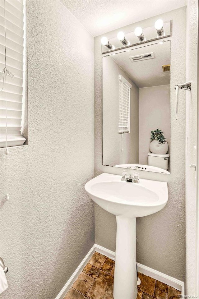 bathroom featuring a textured ceiling and toilet