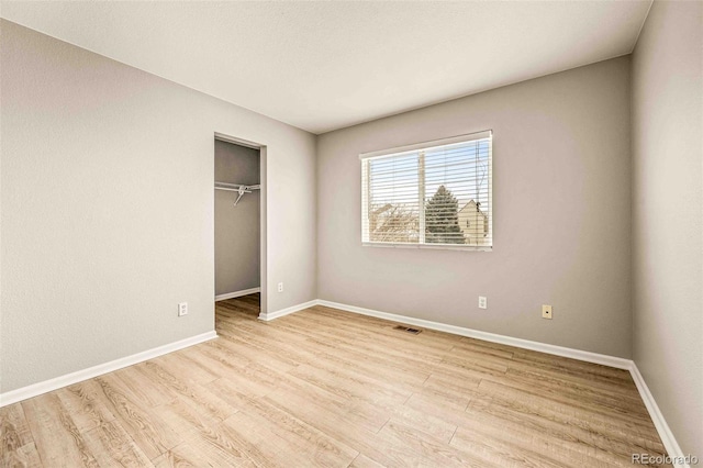 unfurnished bedroom with light hardwood / wood-style floors and a closet