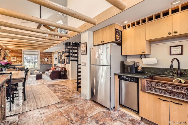 kitchen featuring dark countertops, beam ceiling, appliances with stainless steel finishes, and light brown cabinets