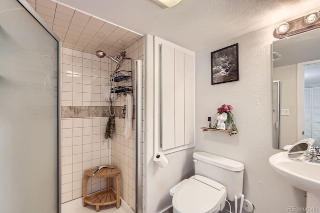 full bathroom with toilet, a sink, and a stall shower