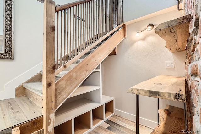 staircase with baseboards and wood finished floors