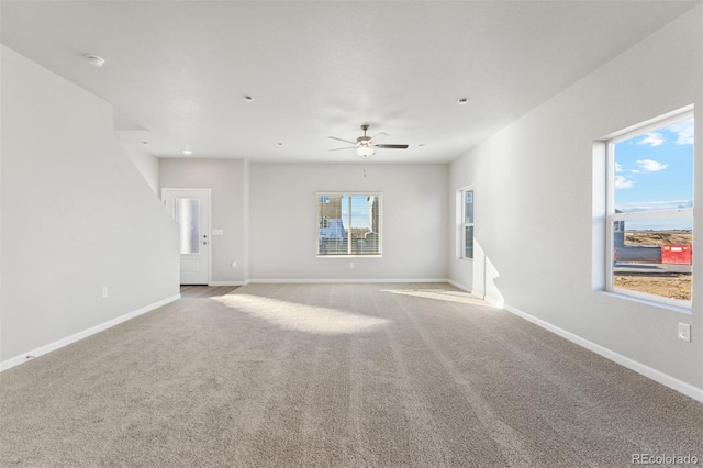 carpeted spare room featuring ceiling fan