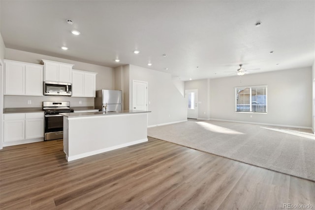 kitchen featuring appliances with stainless steel finishes, white cabinets, and light hardwood / wood-style floors