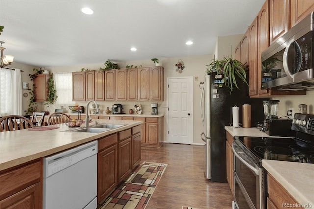 13415 Kearney St, Thornton, CO 80602 - kitchen featuring stainless steel appliances, a sink, light countertops, dark wood finished floors, and recessed lighting