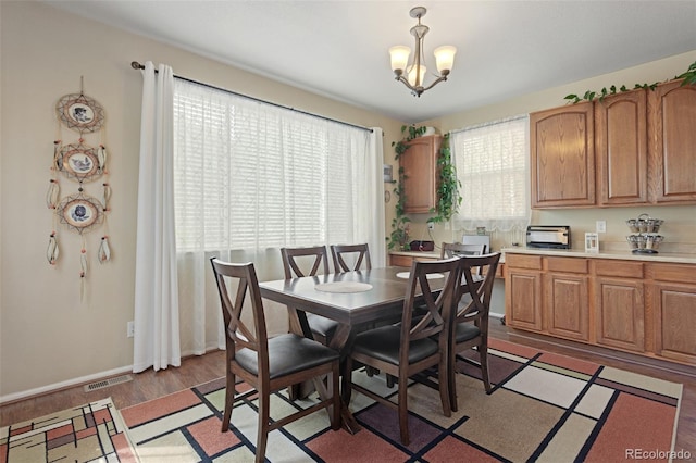 13415 Kearney St, Thornton, CO 80602 - dining area featuring a chandelier, light wood-style flooring, and baseboards