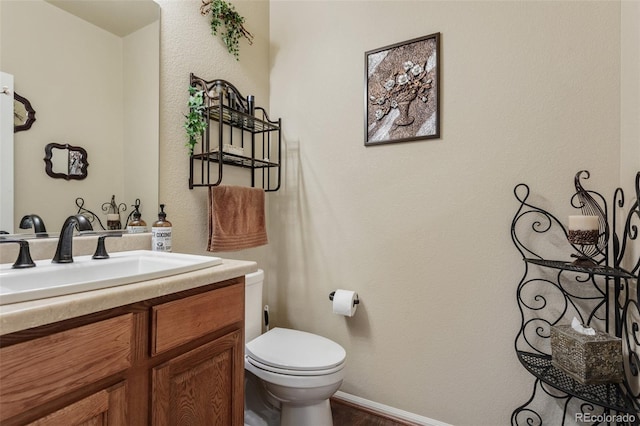 13415 Kearney St, Thornton, CO 80602 - bathroom featuring vanity, toilet, wood finished floors, and baseboards
