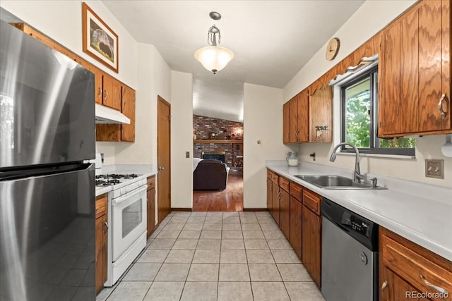 8427 S Custer Ln, Evergreen, CO 80439 - kitchen with appliances with stainless steel finishes, under cabinet range hood, brown cabinets, light countertops, and light tile patterned floors