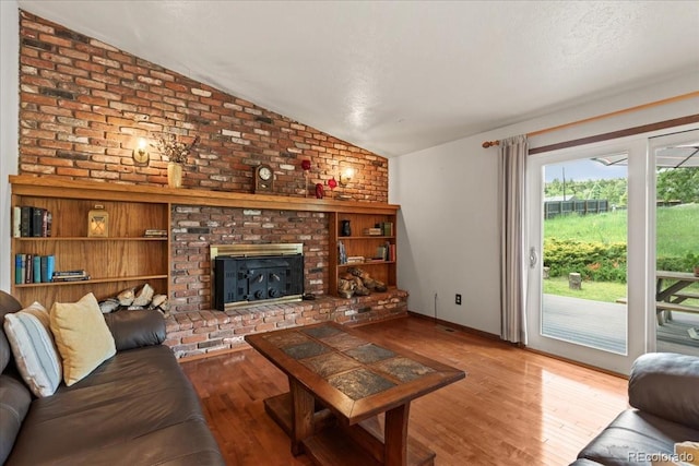 8427 S Custer Ln, Evergreen, CO 80439 - living room with vaulted ceiling, wood finished floors, and a brick fireplace