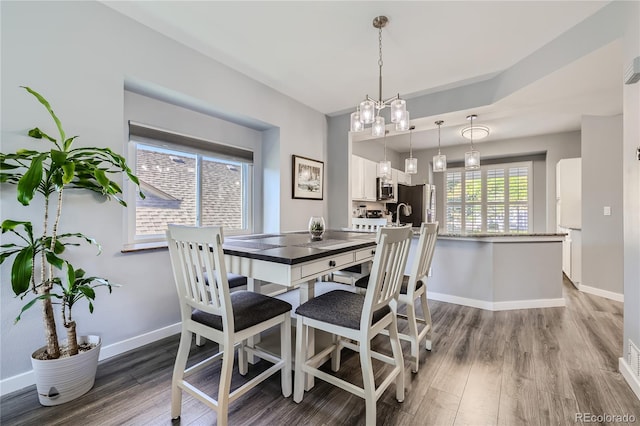 dining space with an inviting chandelier and wood-type flooring