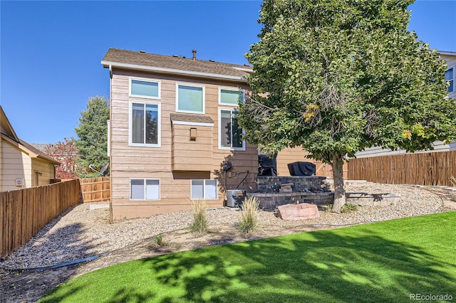 rear view of property featuring a lawn