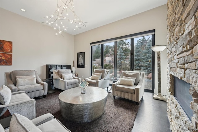 living area with a fireplace, wood finished floors, an inviting chandelier, and recessed lighting