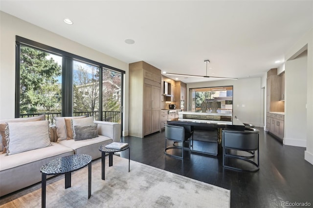 living area with baseboards, dark wood-type flooring, and recessed lighting