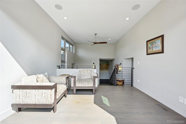 sitting room featuring recessed lighting, wood finished floors, an upstairs landing, baseboards, and ceiling fan