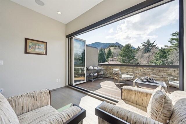 interior space with baseboards, wood finished floors, recessed lighting, and a mountain view