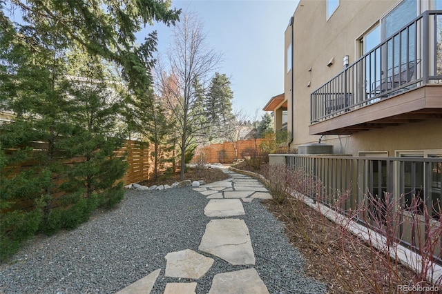 view of yard featuring fence and a balcony