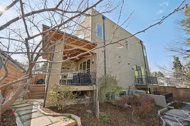 view of property exterior with fence and stucco siding
