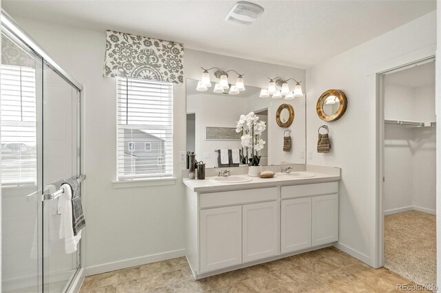 bathroom with vanity and a shower with door