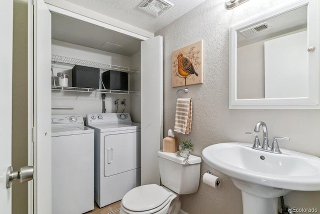 6650 E Arizona Ave Unit 154, Denver, CO 80224 - bathroom with a textured wall, a sink, washer and dryer, and toilet
