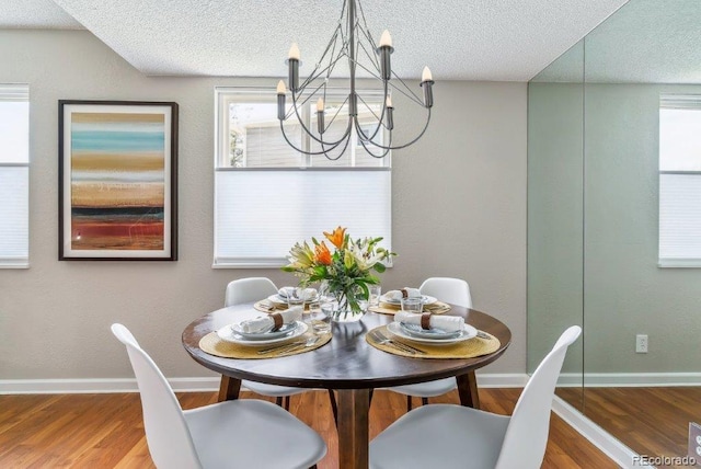 6650 E Arizona Ave Unit 154, Denver, CO 80224 - dining space featuring a chandelier, a textured ceiling, healthy amount of natural light, and wood finished floors