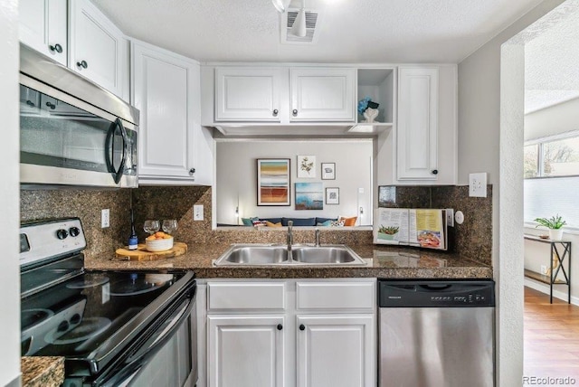 6650 E Arizona Ave Unit 154, Denver, CO 80224 - kitchen featuring stainless steel appliances, white cabinetry, backsplash, and wood finished floors