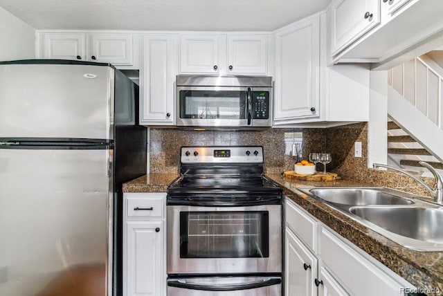 6650 E Arizona Ave Unit 154, Denver, CO 80224 - kitchen featuring appliances with stainless steel finishes, white cabinetry, dark countertops, and backsplash