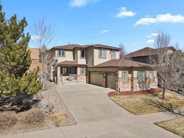 prairie-style house with a garage, stone siding, covered porch, and concrete driveway