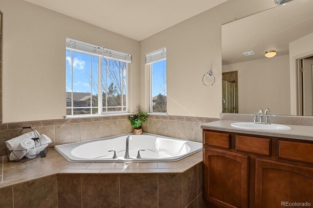 bathroom with a shower stall, visible vents, a bath, and vanity