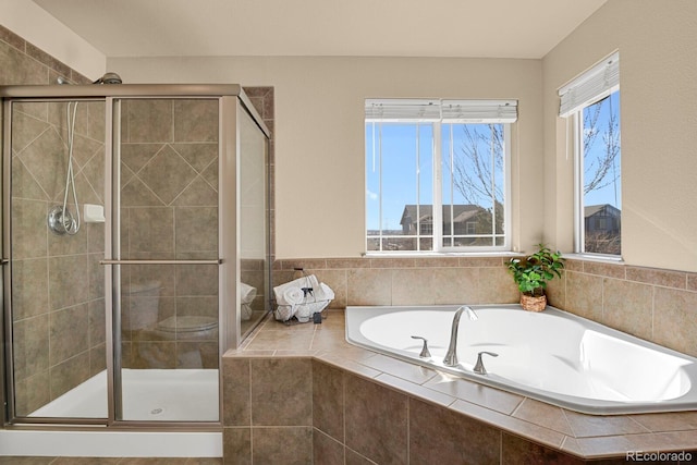 bathroom with a stall shower and a bath