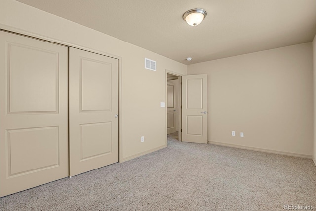 unfurnished bedroom with a closet, carpet flooring, visible vents, and baseboards