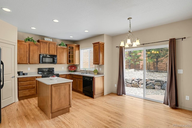 24269 E Arapahoe Pl, Aurora, CO 80016 - kitchen featuring black appliances, light wood-type flooring, light countertops, a chandelier, and brown cabinets