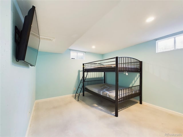 bedroom with multiple windows, light colored carpet, and baseboards