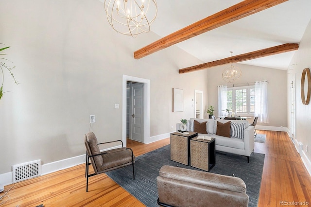 living area with beamed ceiling, a notable chandelier, wood finished floors, and visible vents