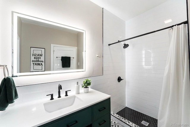 bathroom with vanity, backsplash, tiled shower, and tile walls