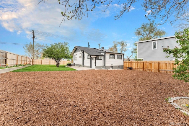 back of property featuring a fenced backyard, a patio area, and a yard