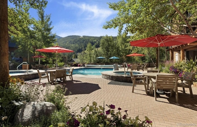 150 Dercum Sq Unit 8501, Keystone, CO 80435 - pool with outdoor dining space, a mountain view, a hot tub, and a patio area
