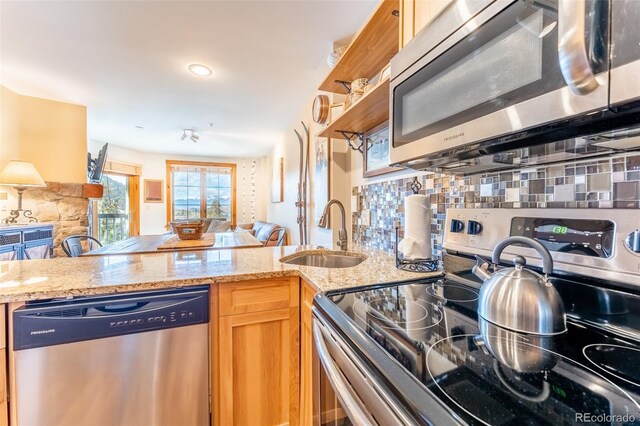 150 Dercum Sq Unit 8501, Keystone, CO 80435 - kitchen with light stone countertops, tasteful backsplash, appliances with stainless steel finishes, a sink, and open floor plan