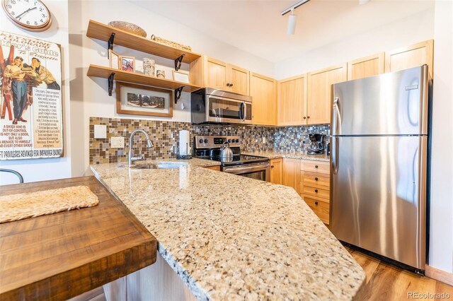 150 Dercum Sq Unit 8501, Keystone, CO 80435 - kitchen featuring light stone counters, backsplash, a sink, light brown cabinets, and stainless steel appliances