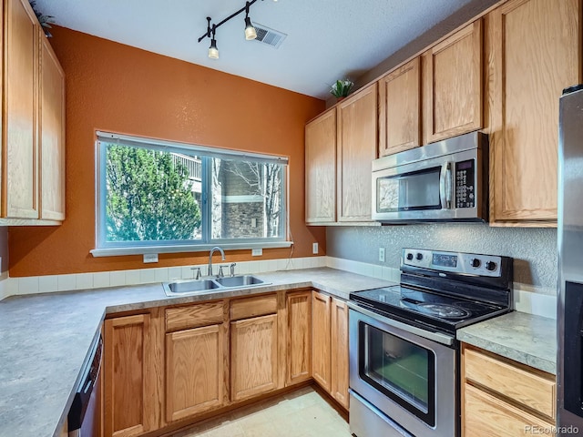 kitchen with sink, track lighting, and appliances with stainless steel finishes