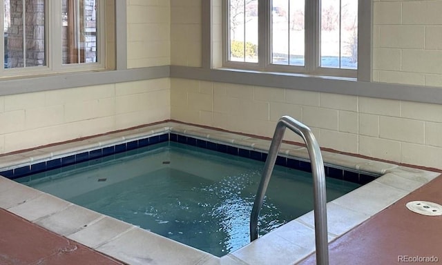 view of swimming pool featuring an indoor hot tub