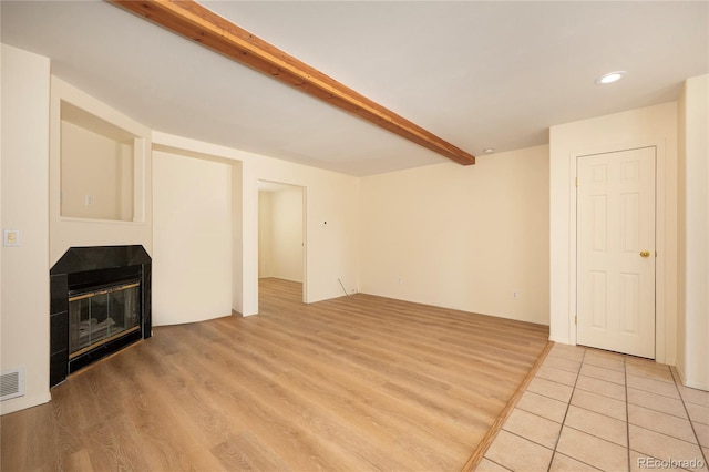 753 County Road 830 Unit 1, Fraser, CO 80442 - unfurnished living room featuring light wood-style floors, beamed ceiling, a glass covered fireplace, and recessed lighting